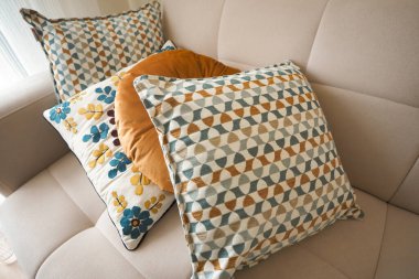 Renkli yastıklar rahat bir oturma odasındaki kanepeye konur..