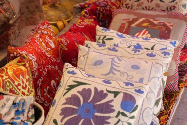 Bir pazarda çeşitli desenlere ve renklere sahip yastıklar düzenlenir.