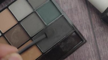 Kişi bir görünüm oluşturmak için bir fırça ile koyu renk göz farı uygular.