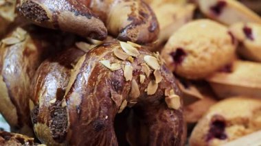 Müşteriler, çeşitli taze ürünlerin sergilendiği bir pastaneyi keşfediyorlar..