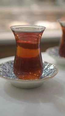 İnsanlar öğleden sonra sıcak bir kafe ortamında toplanıp çay yudumlarlar..