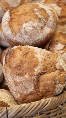 Ekmekler bir markette sepette sergilenir. İnsanlar taze şeyler alır..