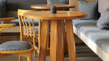 Ahşap masa ve sandalyeler kafe alanını dolduruyor..