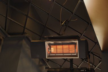 Duvara monte edilmiş ısıtıcı açık ve bir odada ısı yayıyor..