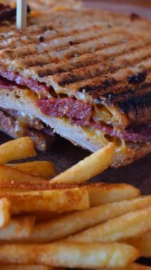 Lezzetli bir sandviç, bir lokantada patates kızartmasının yanında oturur..