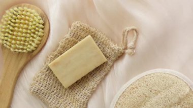 Bir kalıp sabun, yanında fırça olan doğal bir keseye dayanır..