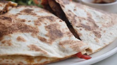 İnsanlar kalabalık bir restoranda salsa soslu quesadilla yiyorlar..