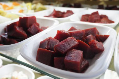 Renkli, sağlıklı vejetaryen yemekleri için beyaz kâselerde taze pancar küpleri..