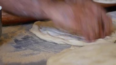 Mutfakta ekmek yaparken eller hamurla uğraşır..