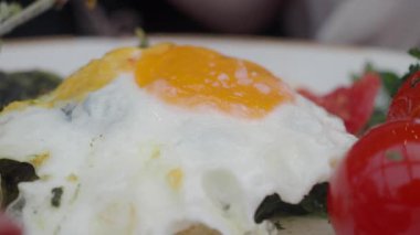 Restoranda bir tabakta pişmiş yumurta ve domateslerin yakın görüntüsü..