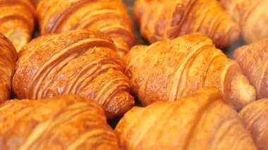 İnsanlar sabahları yerel bir pastanede sergilenen taze kruvasanlardan hoşlanırlar..