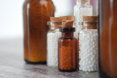 Masada homeopatik ilaç bulunan küçük cam şişeler..