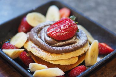 Bir yığın krep çilek ve muzla servis edilir..