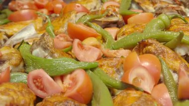 Bir aşçı tavuğu yeşil biberli ve tavada domatesli hazırlar..
