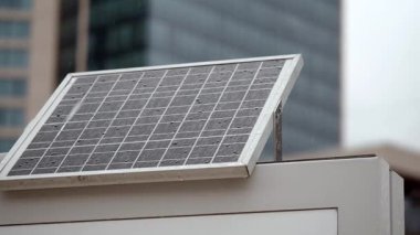 Güneş paneli yoğun bir şehir ortamında çatıda enerji topluyor..