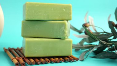 Zeytin sabunu bambunun üzerine istiflenmiş ve yakınlarda yapraklar var.