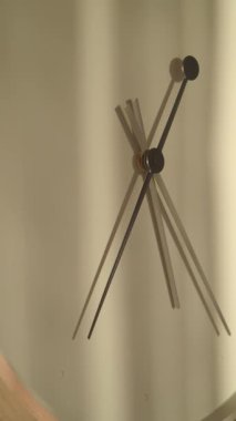 Saatin elleri duvarda hareket eder ve ilginç gölgeler yaratır..