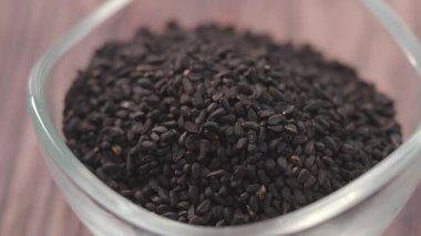 Küçük bir kaseye dökülen siyah kimyon tohumları..