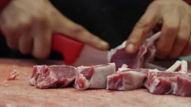Kesme tahtasında çiğ kuzu pirzolası kesen Şefin Yakın Çekimi.