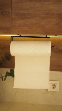 Bir rulo kağıt havlu tezgahın üstündeki tutucudan sarkıyor..