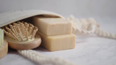 İki kalıp sabun basit bir ayar içinde ahşap bir tarağın yanında oturur..