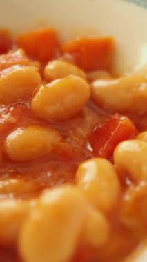 Beyaz fasulyeler yemek için bir kasede domatesle pişirilir..