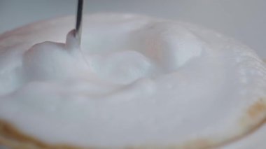 Bir kahveci bir kafede üzerine kalın köpüklü kahve hazırlar..