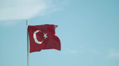 Türk bayrağı bulutlu açık mavi gökyüzüne dalgalanıyor.
