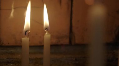 Loş bir alanda iki mum yavaşça yanar ışık ve sıcaklık yaratır..