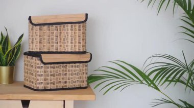 İki hasır sepet yeşil bitkilerin yanındaki ahşap masada duruyor..