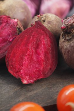 Pancar kökleri ve kiraz domatesleri tahta tezgah yüzeyine yerleştirilmiş..