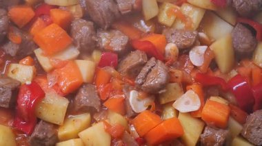 Biftek ve sebze, sağlıklı bir yemek için tencerede birlikte pişirilir..