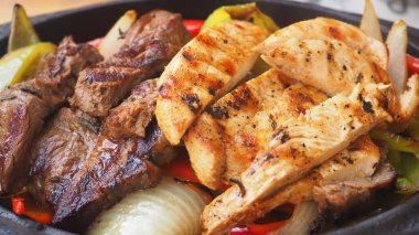 Et, restoran ortamında sebzelerle birlikte elektrikli ocakta pişiyor..