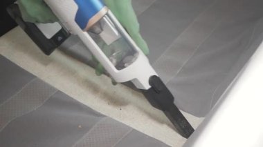 Kanepedeki kiri elektrikli süpürgeyle temizliyorum..