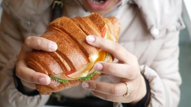 Bireyler öğle yemeğinde elmalı peynirli kruvasan sandviçi yer..