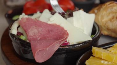 Bir tabak dolusu et, peynir ve meyve dışarıda gün ışığında servis edilir..