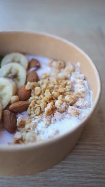 Yoğurtlu, tahıllı, muzlu ve bademli bir kase.