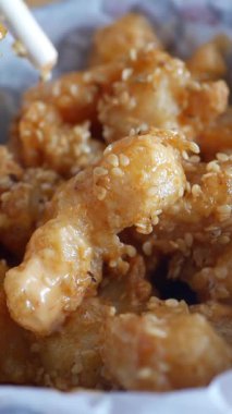 Altın kaplama ve soslu gevrek susamlı karidese yakından bakın..