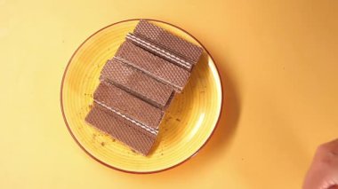 Gofretler, turuncu arka planda bir tabakta otururlar..