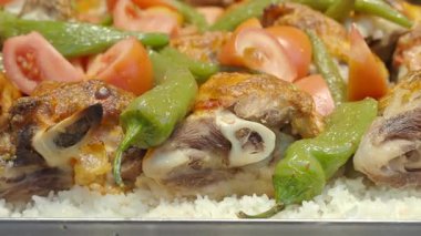 Bir şef mutfakta tavuk ve sebzeli pilav hazırlar..