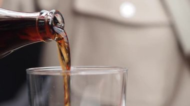 Masadaki bir bardağa şişeden meşrubat dolduruyorum..