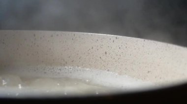 Makarna ocakta suda kaynıyor. Tencereden buhar yükseliyor..