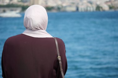 İstanbul 'da suyun kenarında bir kadın dikiliyor ve şehre bakıyor..