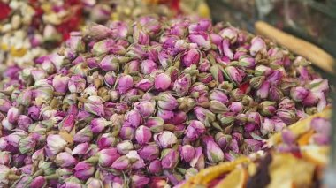 İnsanlar Türkiye 'de bir pazarda kurumuş gül tomurcuklarına bakıyorlar. Güneş batıyor..