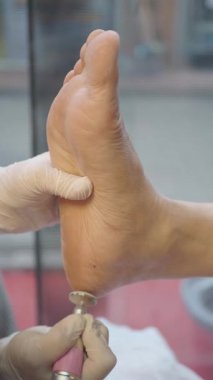 Bir insan kuaförde ayağının üzerinde tedavi görüyor..