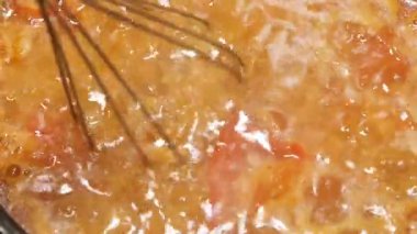 Birisi sebzelerden yapılmış bir sosu fırında pişirir..