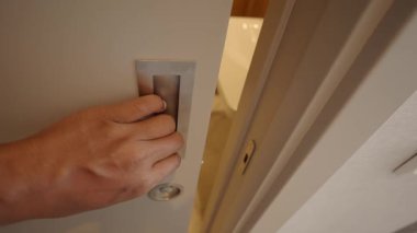 Bir el, yeni bir alana girmek için kapı koluna uzanır..