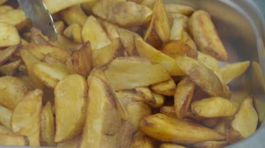 Sıcak patates dilimleri büyük bir tepside servis edilmeye hazır..