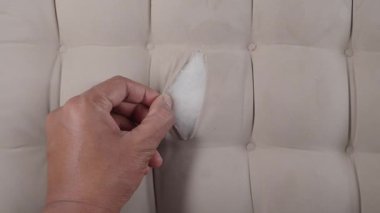 Bir insan koltuktaki yırtığı basit aletler ve tekniklerle tamir eder..