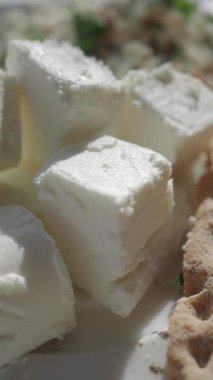 Peynir küpleri ve ekmek beyaz bir tabakta bir araya getirilir..